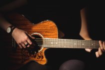 Metà sezione di donna che suona la chitarra nella scuola di musica — Foto stock