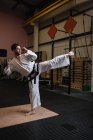Вид сбоку на человека, практикующего каратэ в фитнес-студии — стоковое фото