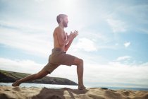Чоловік виконує розтяжку вправи на пляжі — стокове фото