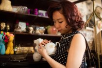 Стильна жінка вибирає чайний горщик в антикварних магазинах — стокове фото