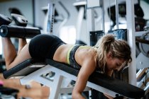 Frau turnt im Fitnessstudio beim Bankdrücken — Stockfoto
