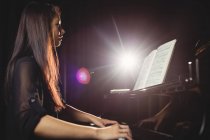 Bella donna che suona un pianoforte in studio di musica — Foto stock