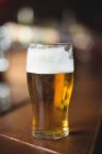 Bicchiere di birra in bancone al bar — Foto stock