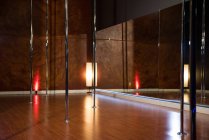 Интерьер современной танцевальной студии для танцев на шесте со светом и зеркалом — стоковое фото