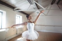 Bailarina en tutú blanco practicando danza de ballet en estudio - foto de stock
