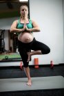 Беременная женщина, занимающаяся йогой в спортзале — стоковое фото