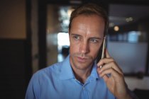 Businessman talking on mobile phone in the office — Stock Photo