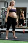 Bella donna incinta che esercita in palestra — Foto stock