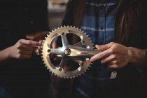 Mid section of mechanics repairing bicycle in workshop — Stock Photo