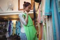 Женщина пробует топ в бутик-магазине — стоковое фото