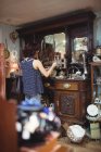 Vista trasera de la mujer de compras de antigüedades en la tienda de antigüedades - foto de stock