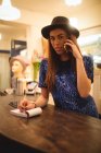 Персонал женского пола принимает заказы на мобильный телефон в бутик-магазине — стоковое фото