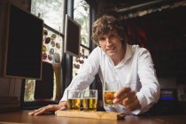 Portrait de barman tenant verre de whisky au comptoir du bar dans le bar — Photo de stock