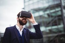 Uomo d'affari utilizzando cuffie realtà virtuale al di fuori dell'ufficio — Foto stock