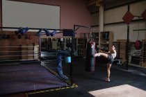 Boxerin übt Boxen mit Boxsack im Fitnessstudio — Stockfoto