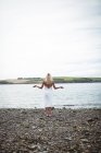 Vista posteriore della donna bionda spensierata in piedi vicino al fiume — Foto stock
