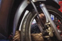Close-up do mecânico examinando moto na oficina — Fotografia de Stock