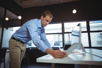Geschäftsmann mit digitalem Tablet und Desktop-PC im Büro — Stockfoto