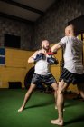 Baixo ângulo de visão de dois boxers tailandeses praticando boxe no ginásio — Fotografia de Stock