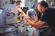 Glassblower working on a glass at glassblowing factory — Stock Photo