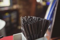 Straws in straw holder at bar counter — Stock Photo