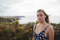Retrato de la mujer de pie sobre el acantilado sobre el mar - foto de stock