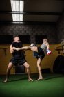 Vista de ángulo bajo de dos boxeadores tailandeses practicando en el gimnasio - foto de stock