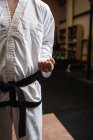 Midsection do homem no karate do quimono que está no estúdio da aptidão — Fotografia de Stock