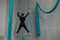 Женская гимнастка, тренирующаяся на синей веревке в фитнес-студии — стоковое фото