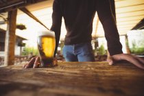 Mittelteil des Mannes mit Glas Bier an der Bar — Stockfoto