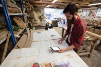 Mann benutzt digitales Tablet beim Betrachten von Bauplan in Bootswerft — Stockfoto