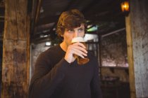 Чоловік має келих пива в барі — стокове фото