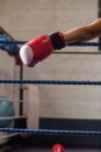 Abgeschnittenes Bild eines Boxers, der sich an Seile des Boxrings lehnt — Stockfoto