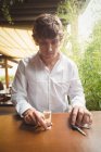 Задумчивый человек, держащий стакан текилы в барной стойке в баре — стоковое фото