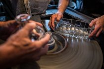 Mains de souffleurs de verre travaillant sur un verre à l'usine de soufflage de verre — Photo de stock