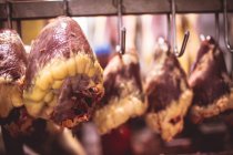 Серця яловичини, що звисають підряд в кімнаті для зберігання в магазині м'ясників — стокове фото
