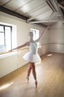 Красивая кавказская балерина, практикующая балетный танец в студии — стоковое фото