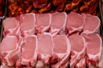 Крупный план сырых стейков в мясной лавке — стоковое фото