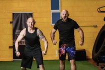 Portrait of two aggressive thai boxers screaming in fitness studio — Stock Photo