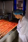Pessoal feminino examinando a qualidade dos ovos no controle de iluminação na fábrica de ovos — Fotografia de Stock