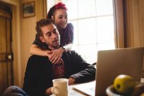 Smiling hipster couple with laptop at home — Stock Photo