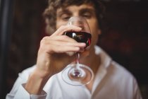 Мужчина выпивает бокал красного вина в баре — стоковое фото