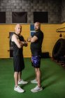 Портрет впевнених тайських боксерів, що стоять з обіймами, схрещеними у фітнес-студії — стокове фото