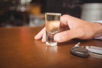 Чоловік тримає склянку текіли застреленої в барі в барі — стокове фото