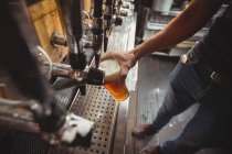 Gros plan de la bière de remplissage de bar tendre de la pompe de bar au comptoir de bar — Photo de stock