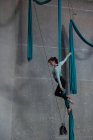 Женская гимнастка, тренирующаяся на синей веревке в фитнес-студии — стоковое фото