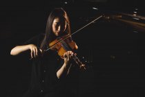 Étudiante jouant du violon dans un studio — Photo de stock