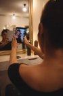 Donna che prende selfie dal cellulare al salone — Foto stock