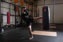 Боксер, практикуючи бокс з боксерської груші в фітнес-студія — стокове фото