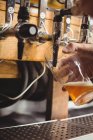 Gros plan de la bière de remplissage de bar tendre de la pompe de bar au comptoir de bar — Photo de stock